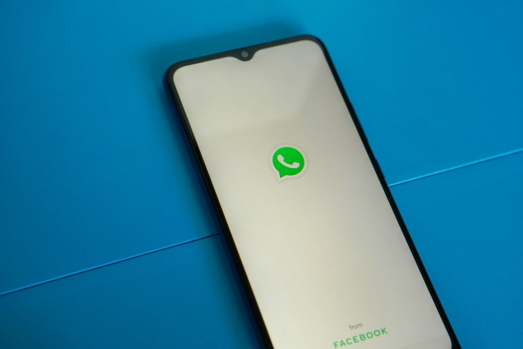 smartphone mostrando tela do WhatsApp em destaque